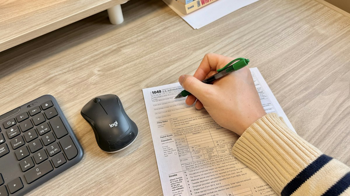 Ranka pildo dokumentą prie kompiuterio biure